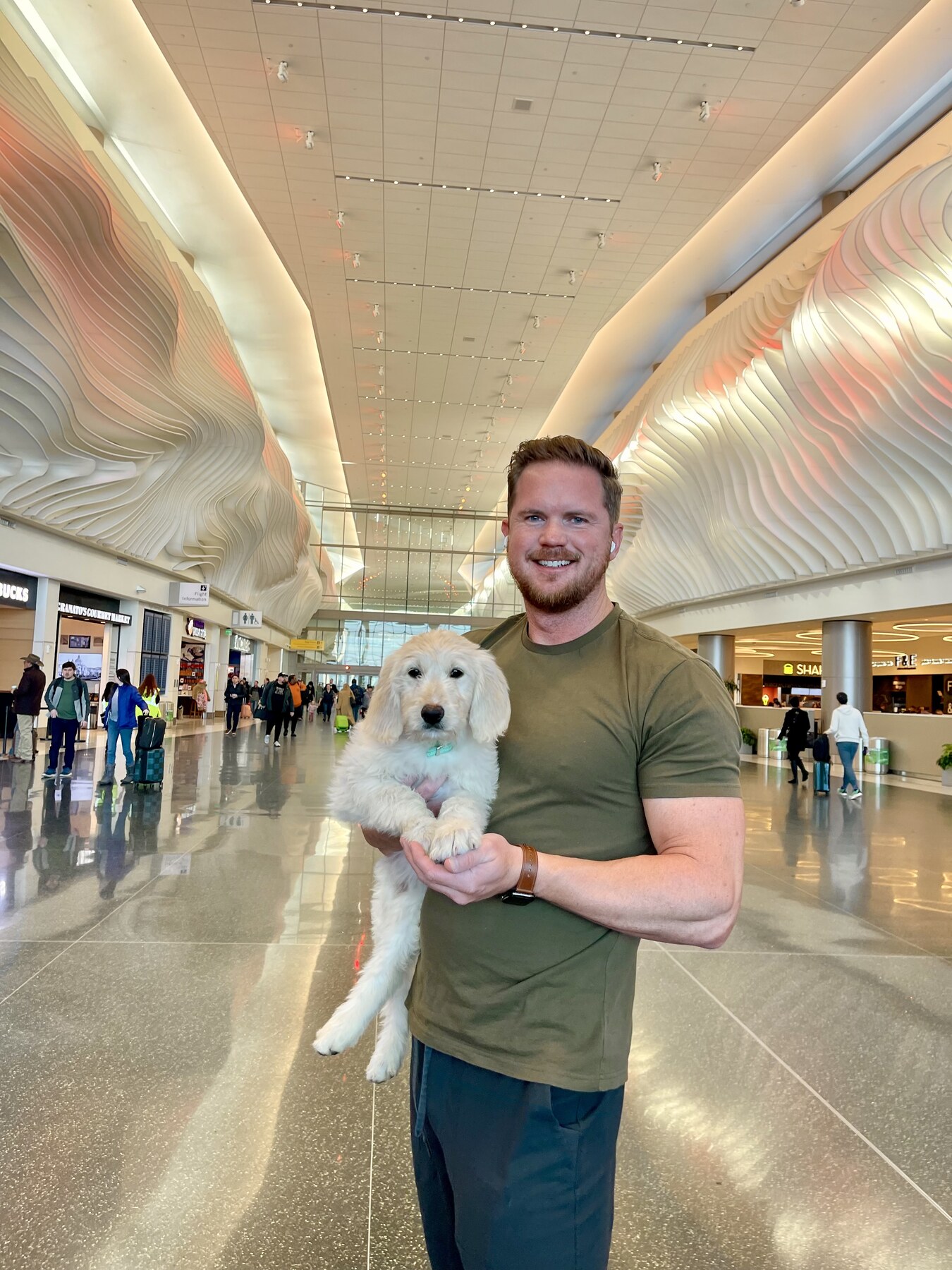 John holding a dog in an airport